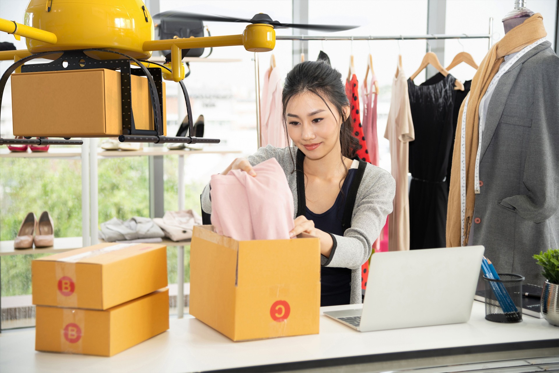 Young asian women packing cloth on box for delivery to customer by air drone, Small business with modern technology shipment innovation and eco concept